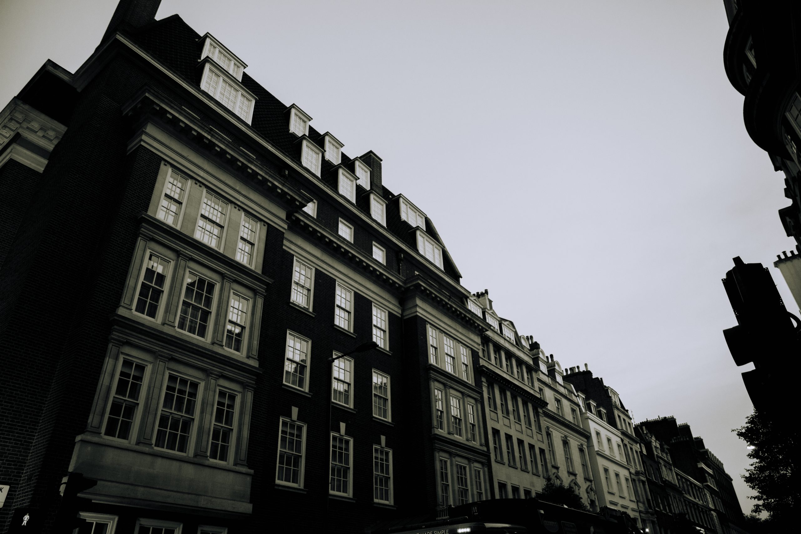 Wide low angle grayscale shot of buildings with windows next to each other
